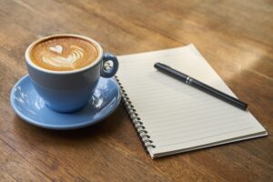 Coffee and notebook on desk